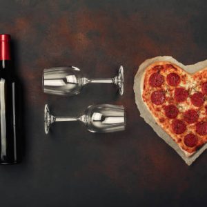 19 pizza und wein (ES:EN:DE) Heart shaped pizza with mozzarella, sausagered , wine bottle and two wineglass. Valentines day greeting card. Top view
